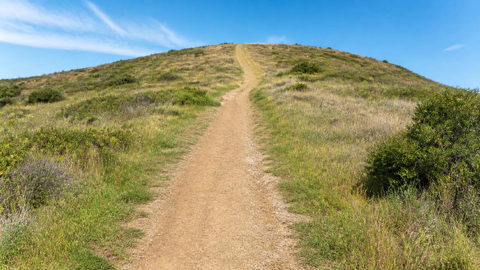 Photographic dirt path climbing a steady hill for hill repeats